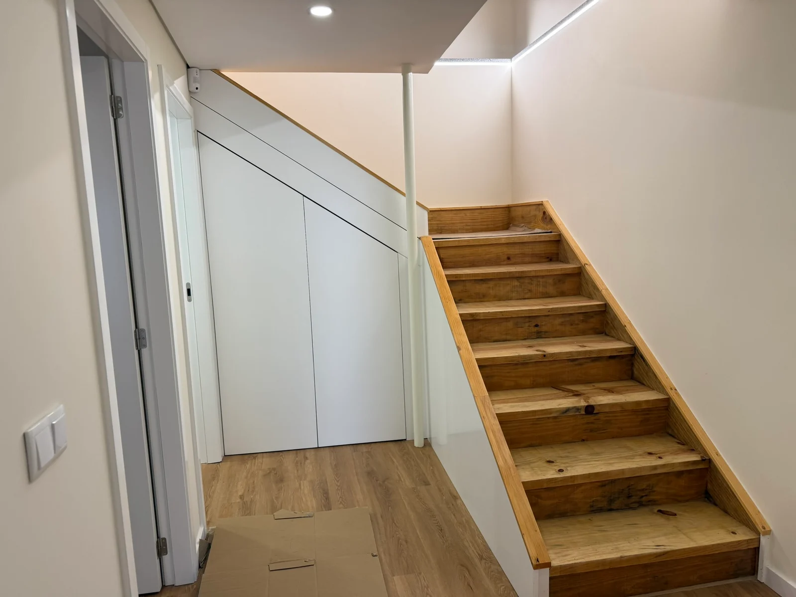 Escadas em madeira e armários sob o lanço de escadas